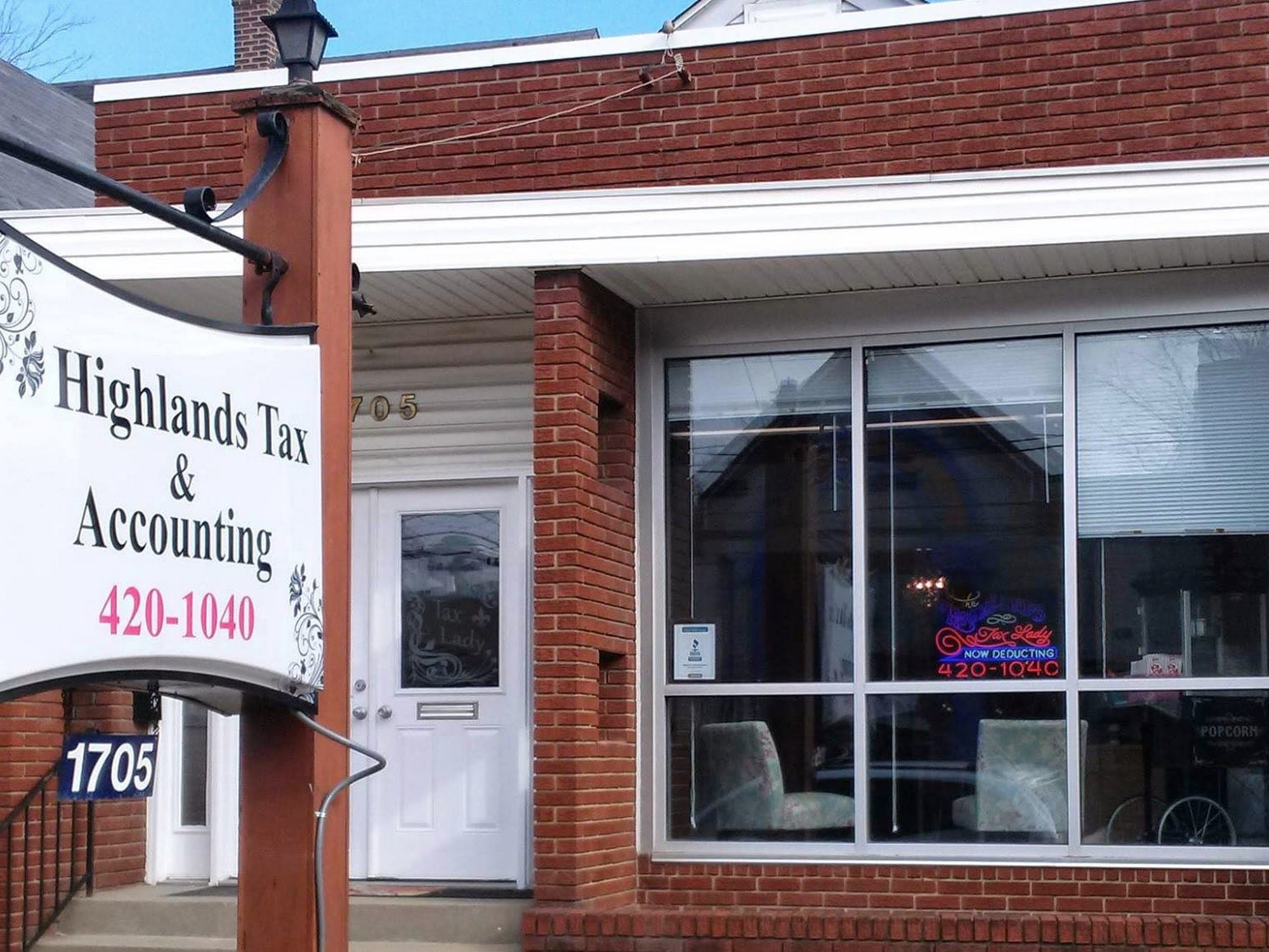The real front entrance at 1705 Bardstown Rd: brick steps up to a white door, with the Highlands Tax & Accounting sign hanging overhead.