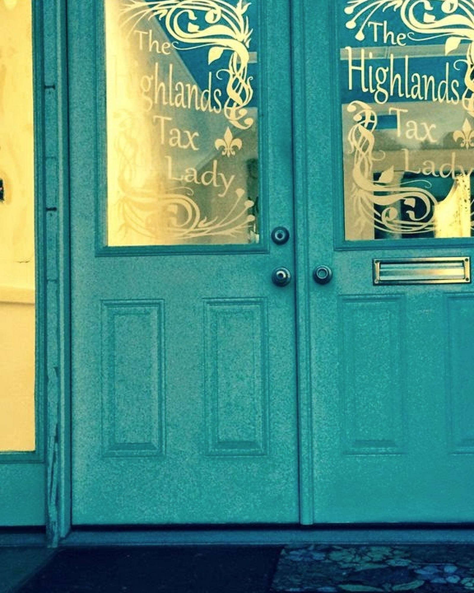 The office's real front doors: a teal double door with ornate gold lettering reading The Highlands Tax Lady.
